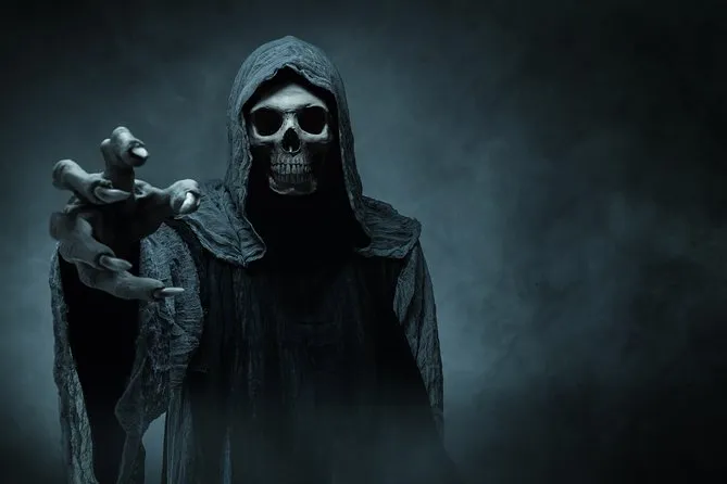 Hooded skeletal grim reaper figure reaching out through gray fog