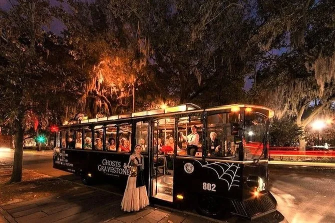 Ghosts and Gravestones black trolley with a costumed guide under mossy oaks at night