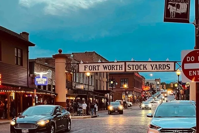 Fort Worth Stockyards archway sign over a lit western street at dusk