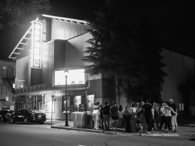 A tour group gathered outside the Orpheum Theater in downtown Flagstaff at night