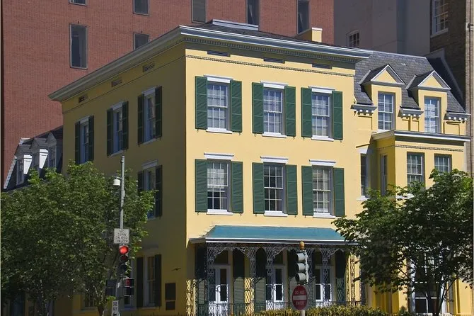Yellow historic townhouse with green shutters on a city corner