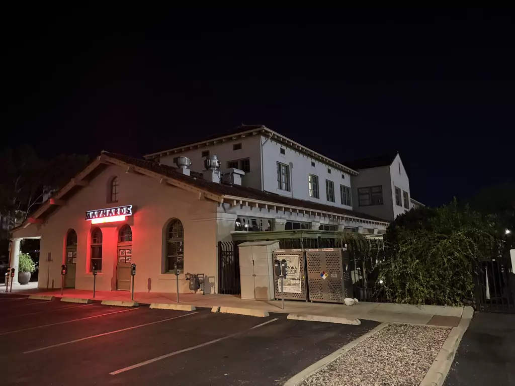Historic Tucson depot building housing Maynards, glowing under red light at night