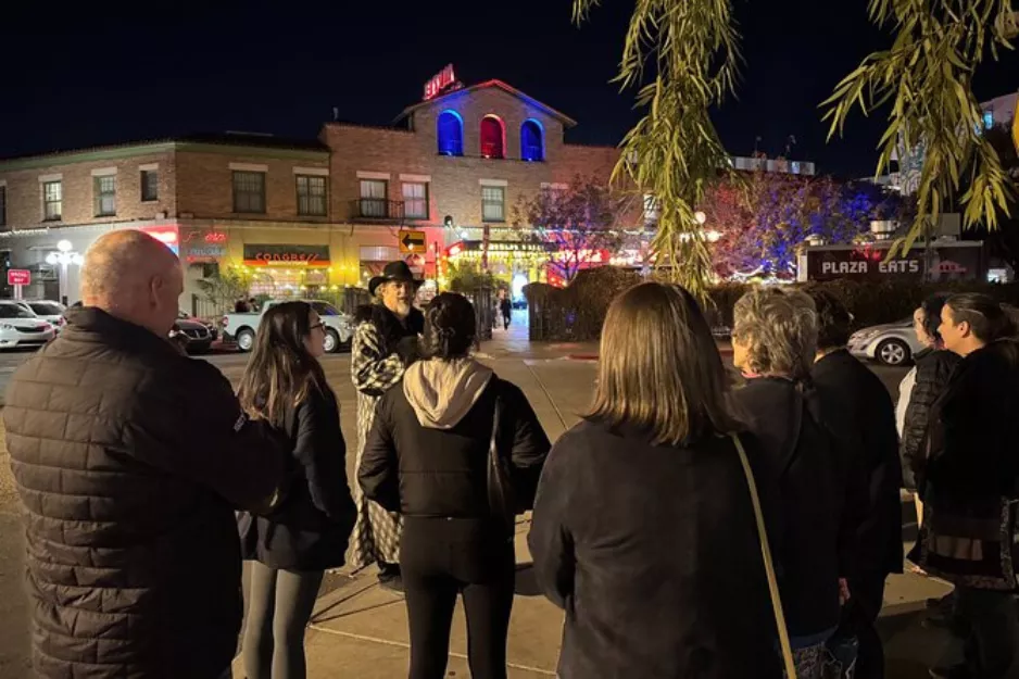 Night tour group with a costumed guide outside Hotel Congress in downtown Tucson