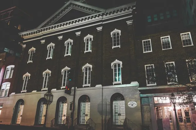 Historic brick building with white-trimmed windows lit at night