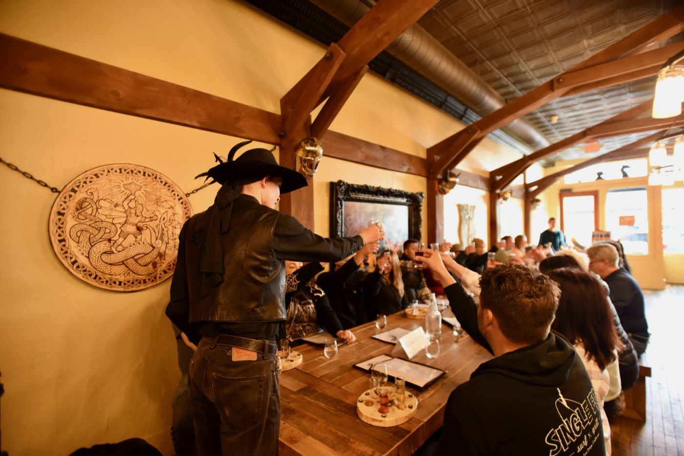 A leather-clad Freaky Foot Tours guide raises a toast and the whole mead hall follows suit, glasses in the air at a Spirits With The Spirits pub crawl stop in Flagstaff.