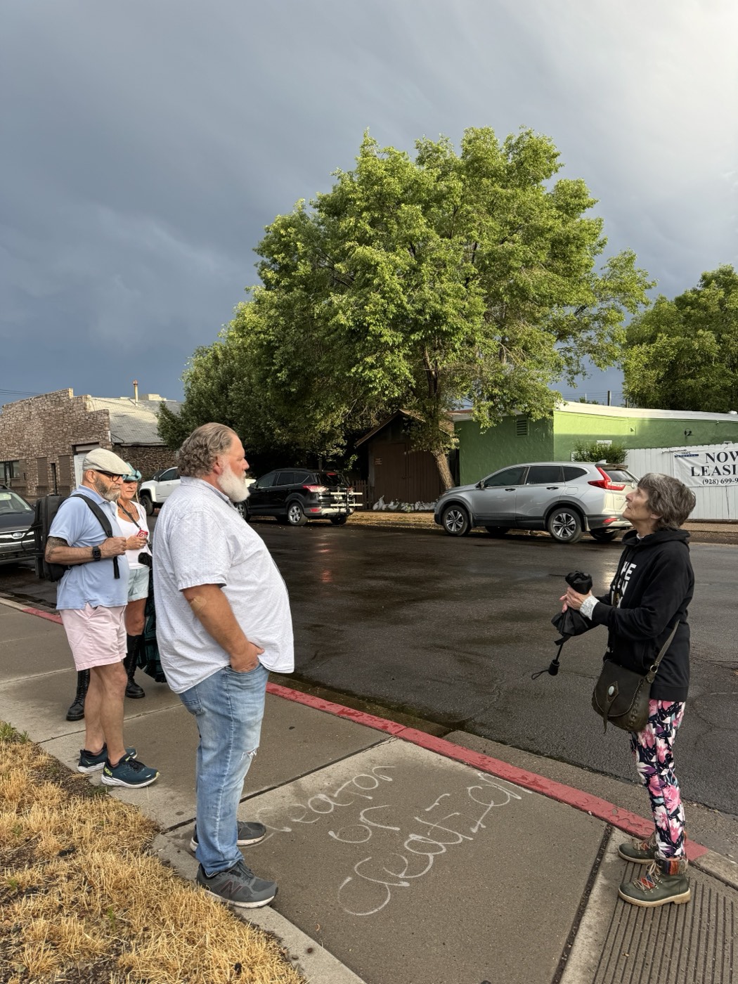 Guests gather over chalk-scrawled sidewalk musings as thunderheads roll over the Southside.