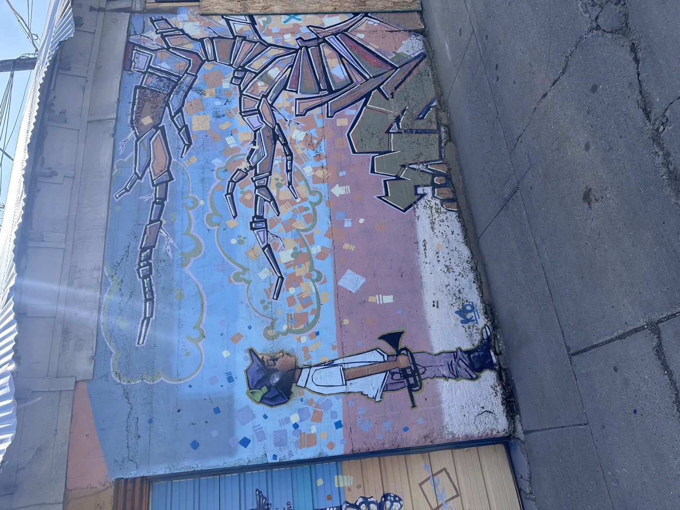 In a back alley off the historic district, a painted boy raises his trumpet to a swirling mechanical scorpion twice his size.