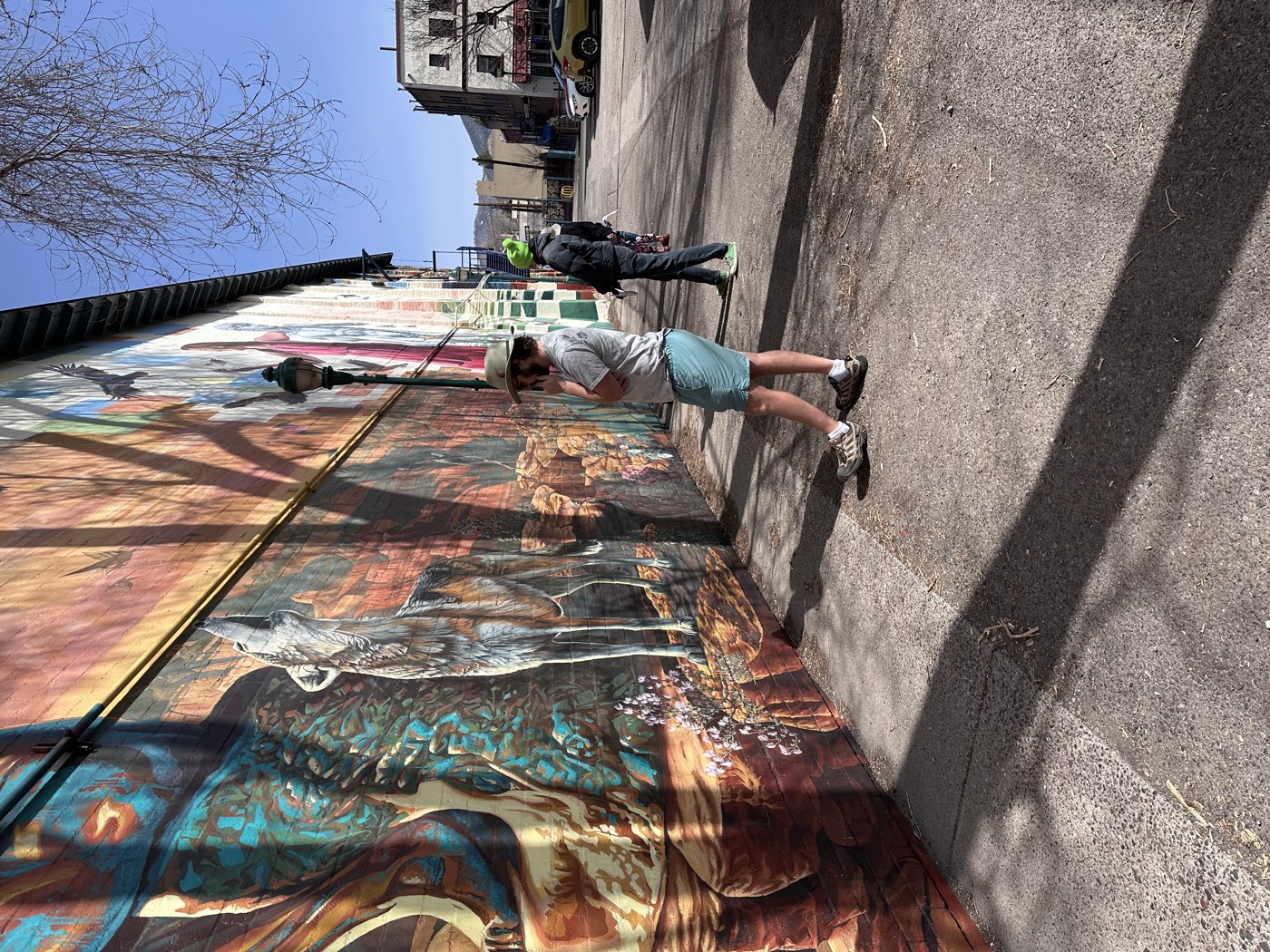A howling wolf rises from painted red rock as guests wander the alley's canyon-sized artwork.