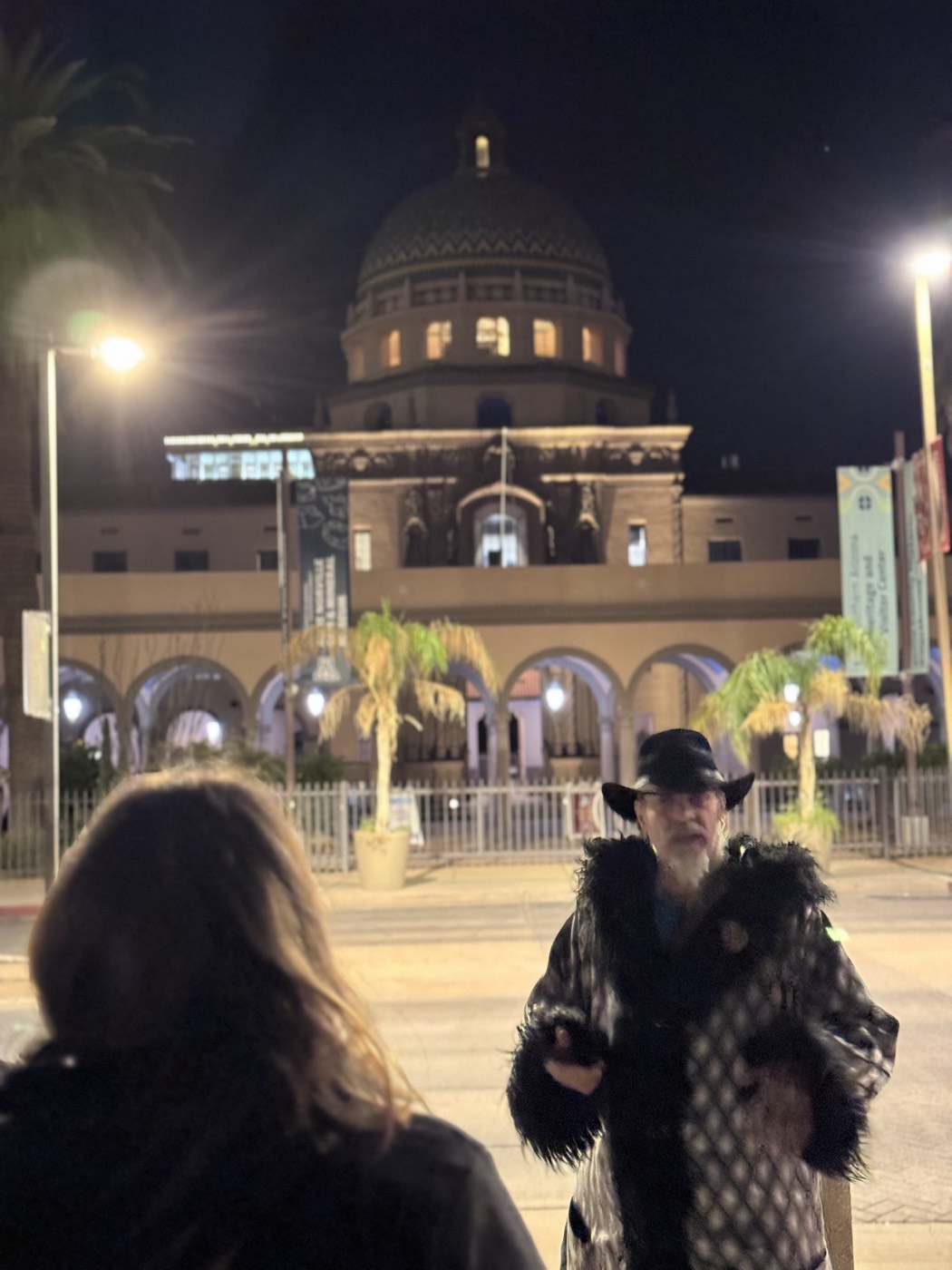 A guide and guest beneath the Pima County Courthouse dome at night