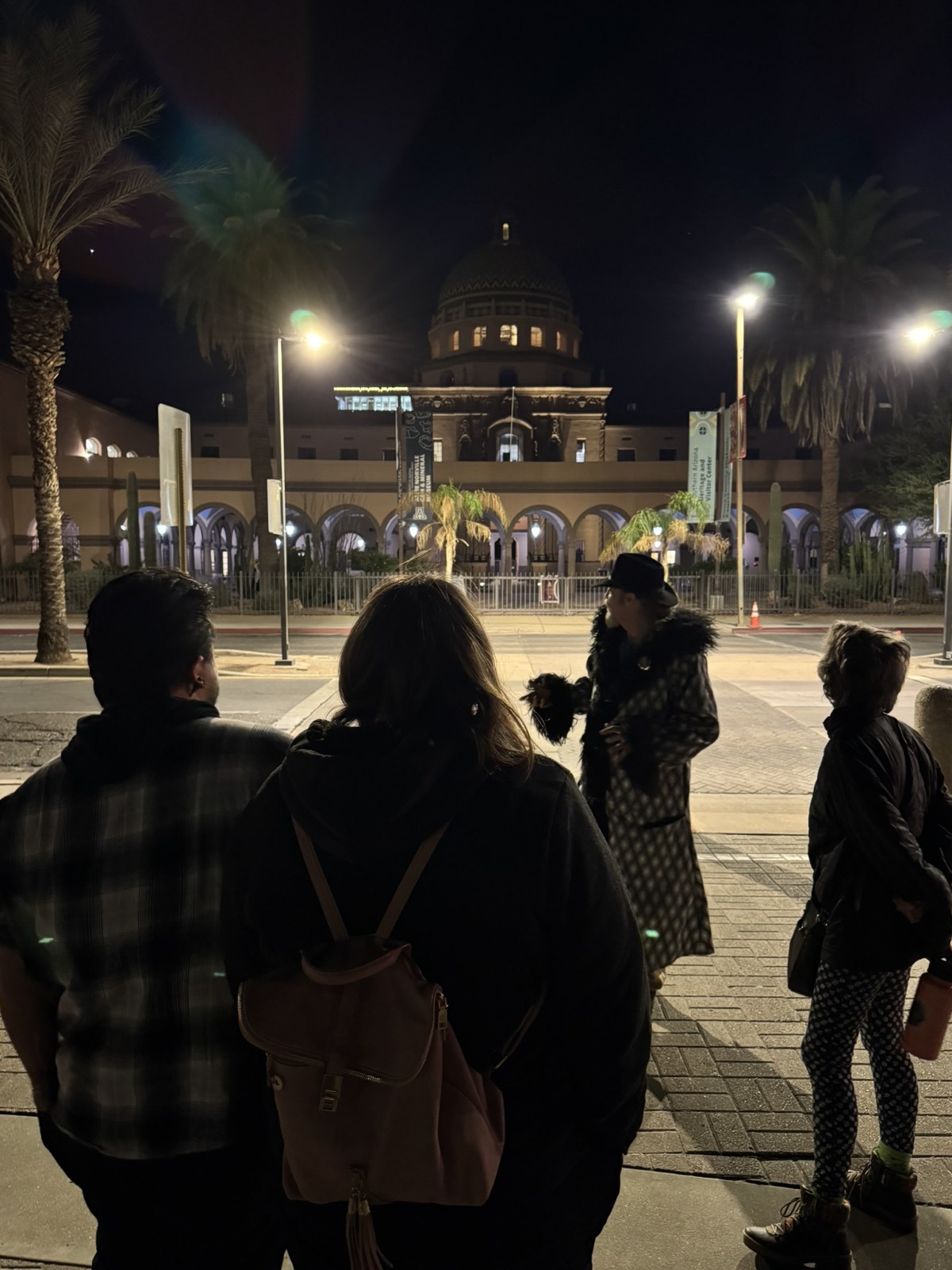A tour group beneath the tiled dome of the old Pima County Courthouse at night
